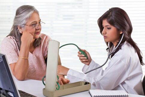O médico mide a presión con hipertensión